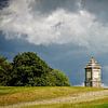 Monument op een heuvel met dreigende lucht van Dirk Huckriede