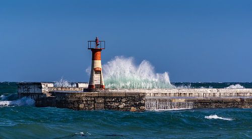 High waves beat against lighthouse