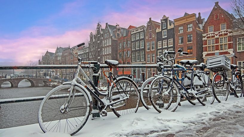 Cityscape of snow-covered Amsterdm in winter in the Netherlands at sunset by Eye on You