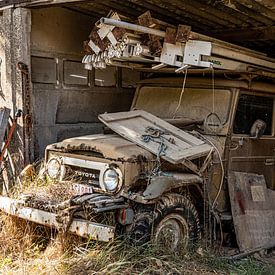 Old dusty car in open storage by Diana Kors