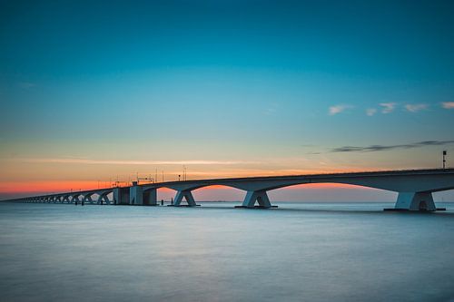 The well-known Zeeland Bridge in the Netherlands during the sunset.