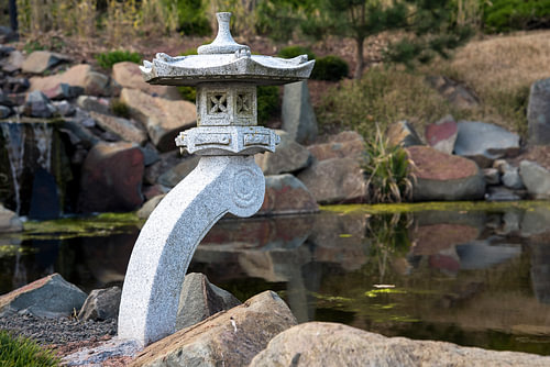 Steinlaterne und Felsen an einem Teich, Gartenlandschaftsgestaltung im japanischen Stil
