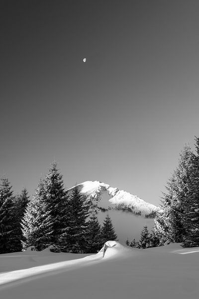 Black and white moon over mountain Iseler in Tannheimer valley with fresh snow by Daniel Pahmeier