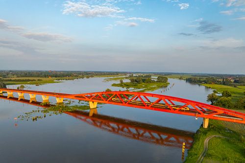 Hanzeboog spoorbrug in een kleurrijke zonsondergang over de IJssel