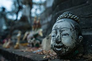 Oud verweerd lachend hoofd van Thais boeddhabeeld op altaar bij tempel van Thijs van Laarhoven