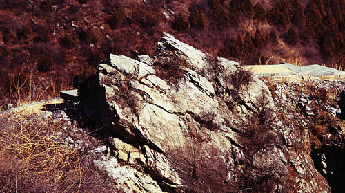 Sunlit Rock Slabs on a Rust-Red Hillside