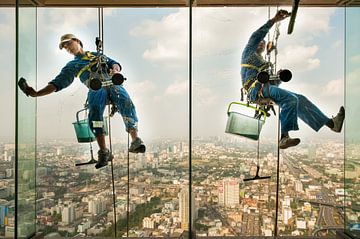 Fensterputzer hängen bei ihrer Arbeit in der Höhe von einem Wolkenkratzer