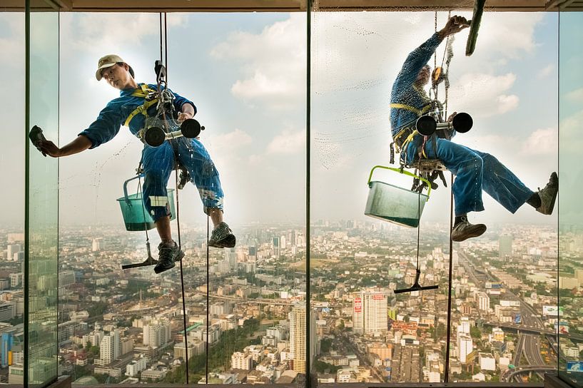 Fensterputzer hängen bei ihrer Arbeit in der Höhe von einem Wolkenkratzer  von Nic Limper
