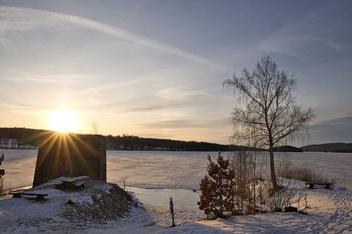 Zonsondergang bij het bevroren meer in Zweden