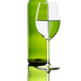 Reflections of a coloured bottle in a wine glass by Roland Brack