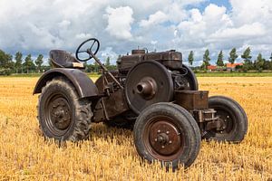 Historische tractor op een stoppelveld van Bram van Broekhoven