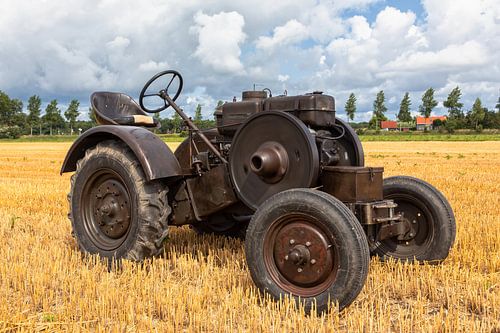 Historische tractor op een stoppelveld