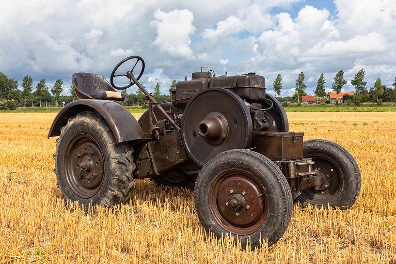 Historische tractor op een stoppelveld van Bram van Broekhoven