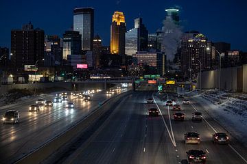 Minneapolis Skyline in de avond, gezien van de brug met de snelweg en autolichten van Eric van Nieuwland