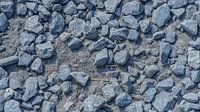 Grey stones on the ground among grit