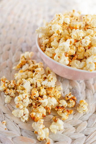 Frisch gemachtes Popcorn liegt in einer Schale auf einem Tisch.