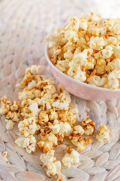 Frisch gemachtes Popcorn liegt in einer Schale auf einem Tisch. von Edith Albuschat