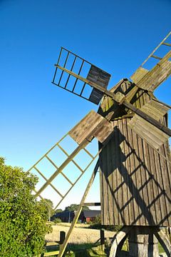 Vieux moulin à vent en bois dans un paysage idyllique sous un ciel bleu