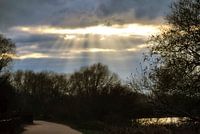 De zon die door de wolken schijnt.