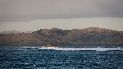 Bootjes op ruige zee met heuvels in Fiji