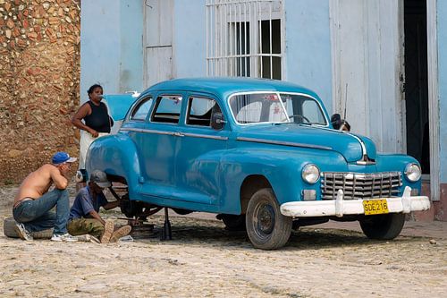 Mannen repareren oldtimer in de straten van Cuba