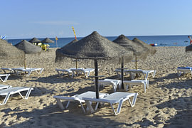 Strand von Luz mit Sonnenschirmen an der Algarve - Portugal