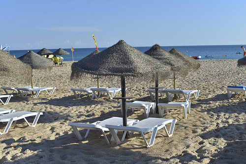 Strand von Luz mit Sonnenschirmen an der Algarve - Portugal