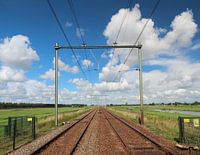 Spoorwegovergang met oneindig spoor naar de horizon met felle blauwe lucht