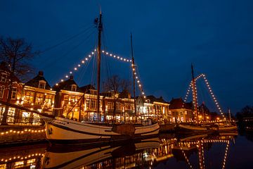 Versierde zeilschepen in de haven van Dokkum bij avond met kerstmis van Eye on You