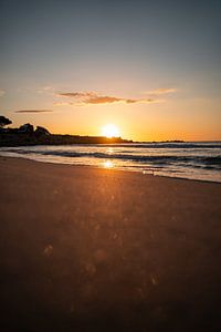 Sonnenaufgang am Strand an der Küste Sardiniens mit glitzerndem Meer