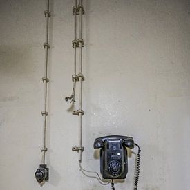 Vieux poste téléphonique accroché au mur sur Michel Knikker