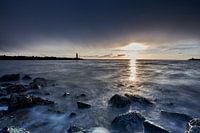 sea against rocks with a stone breakwater in the background