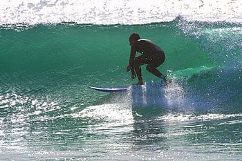 Surfer in einer Tonne am Capo Mannu