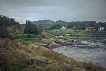 Hügellandschaft mit See und Häusern in Norwegen