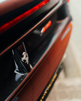 Carbon & chroom – Ferrari-detail met Cavallino-logo achteraan