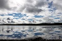 Wolkenlucht weerspiegeld in een Schots meer