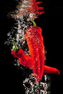 Red peppers under water by Huub Keulers