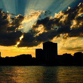 Coucher de soleil à Cologne, rayons de soleil dorés, nuages à la silhouette de ville au ciel bleu. sur 77pixels