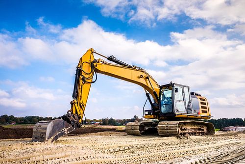Yellow excavator in road construction
