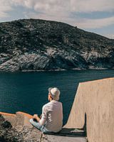 Jongen met hoed kijkt uit over de Mediterraanse zee