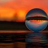 Coucher de soleil à travers une boule de verre sur Alexander Schulz