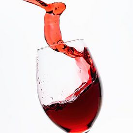 Red wine flows into the wine glass by Roland Brack