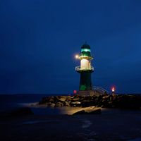 Der Leuchtturm Molenfeuer an der Westmole an der Küste der Stadt Warnemünde bei Nacht