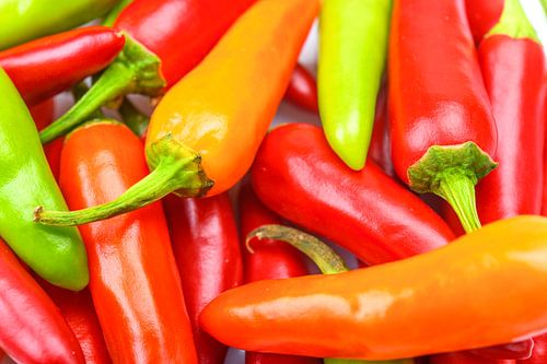 Stapel van hete rode, oranje en groene Chili-paprika's voor gekruid eten