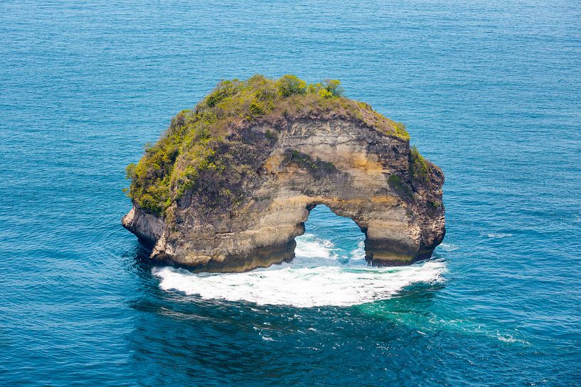Wilde rotsboog in de zee op Nusa Penida in Indonesië van Michiel Ton