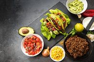 mexikanische Tacos und Zutaten wie gebratenes Hackfleisch, Tomatensalsa, Guacamole, Mais und Gewürze von Maren Winter Miniaturansicht