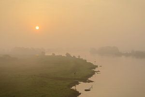 Sunrise over the river IJssel during a foggy morning