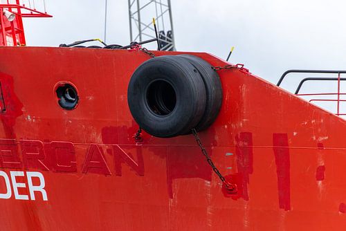 De boeg van het schip ligt zwaar en stil tegen de kade