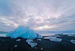 IJs op een zwarte strand van Jökulsárlón IJsland van Anton de Zeeuw