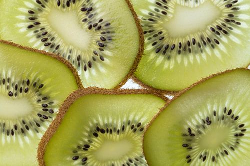 Meerdere plakken van een doorgesneden Kiwi vrucht in tegenlicht opname